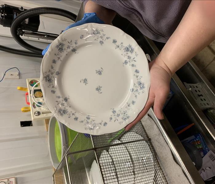Employee holding same dish, now clean