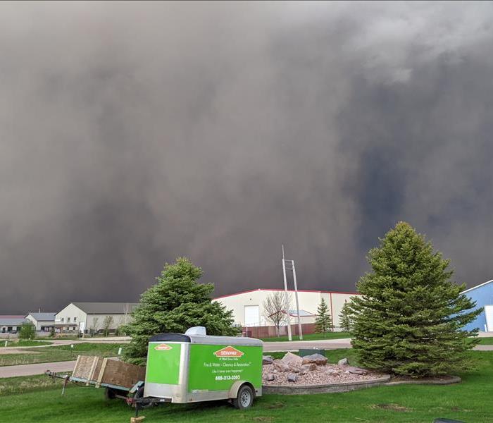 Storm rolling in with green SERVPRO trailer in foreground of picture